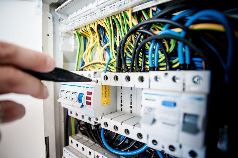 An electrician testing a breaker in a consumer unit