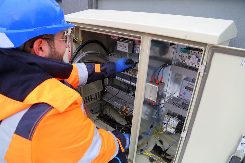 An electrician in hi-vis working inside a distribution cabinet