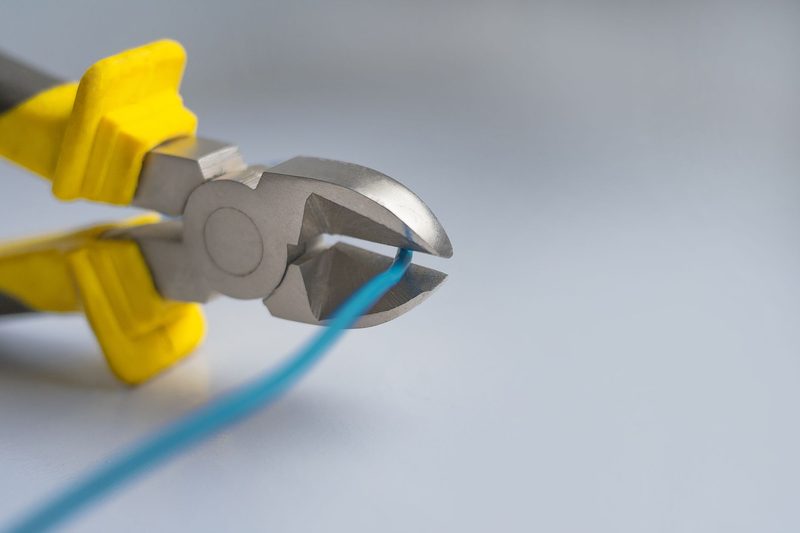 Wire cutters trimming a blue cable