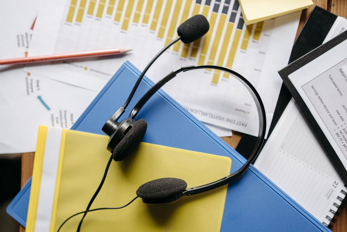 A call headset resting on work folders