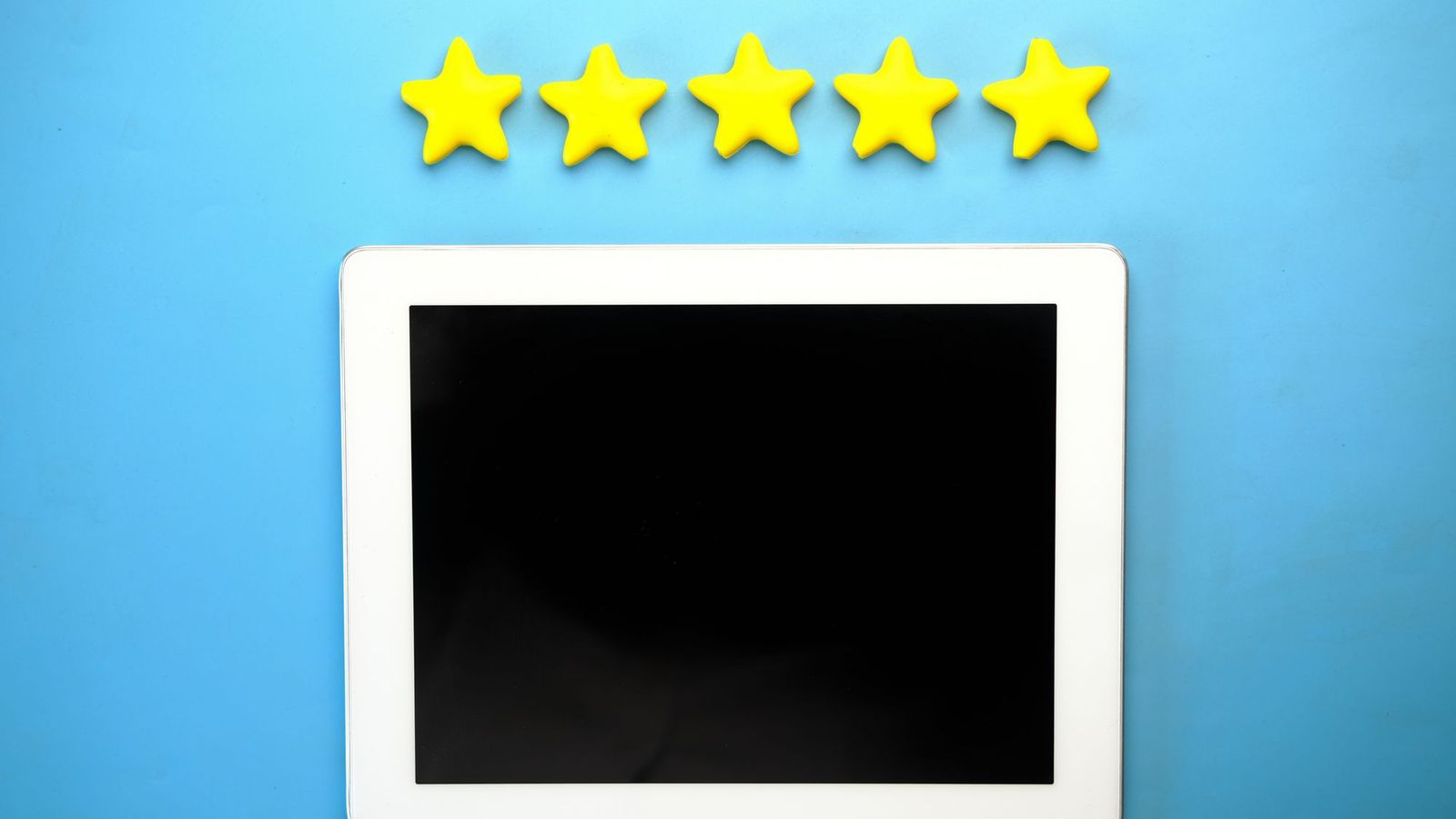 A white tablet on a blue background with five yellow stars above it.