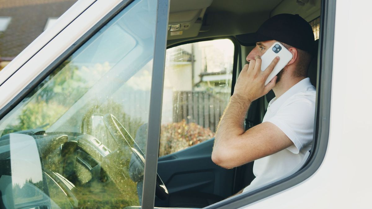 A tradesman taking a call in his van