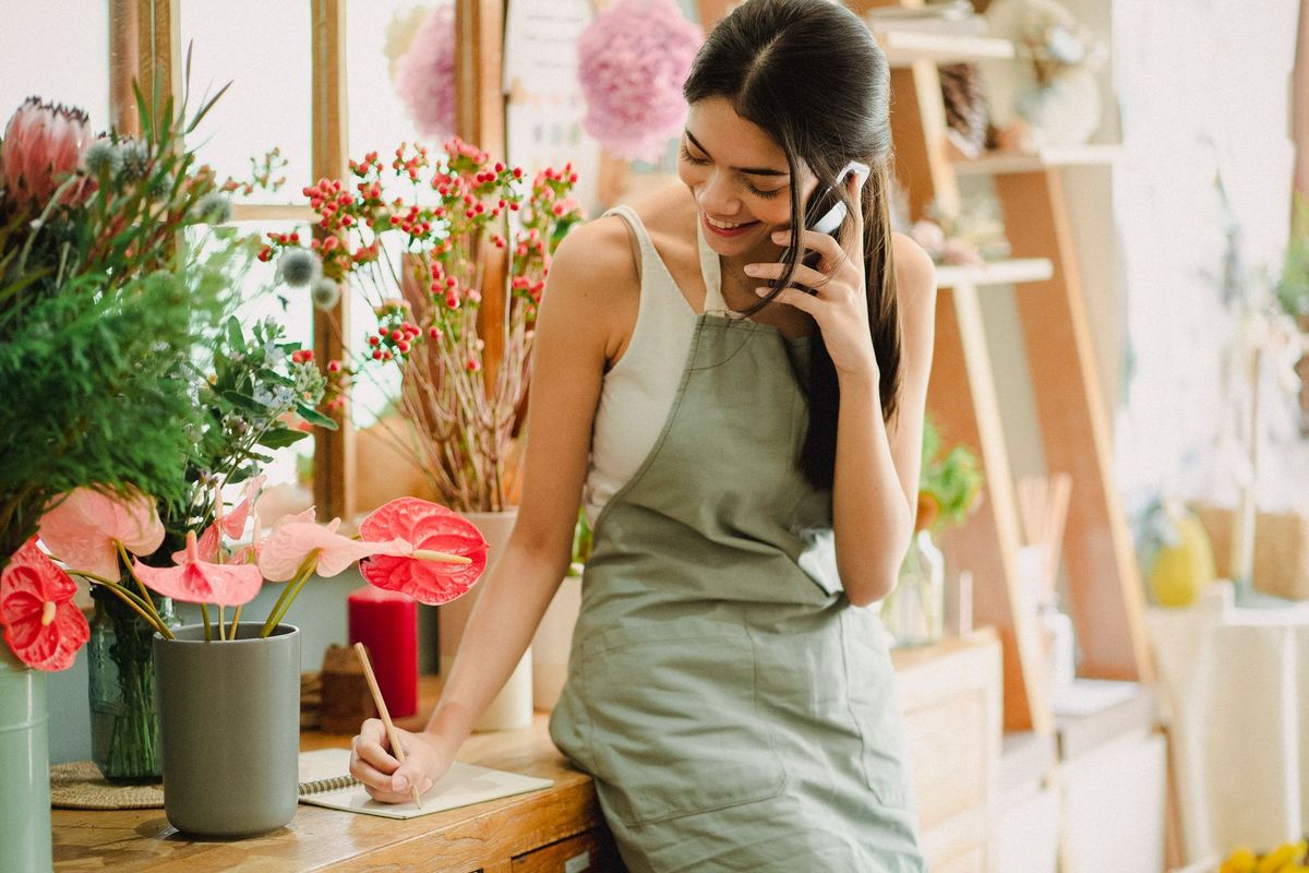 A florist taking a phone call while she works